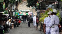 Sejumlah warga tampak lalu lalang di Jalan Petamburan III. Selain itu ada juga yang berkumpul di warung-warung pinggir jalan.