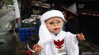 Mulyono, warga Cidodol Kebayoran Lama Jakarta Selatan membawa boneka bersorban saat melintas di Jl Petamburan III.