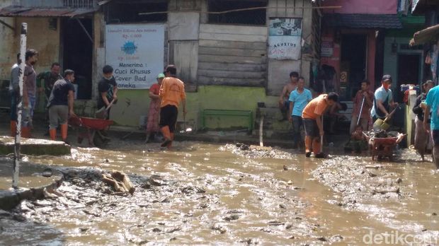 Warga keruk lumpur pascabanjir di Medan.