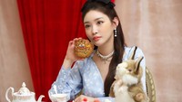 Dalam salah satu sesi pemotretan, Chungha tampil cantik ditemani satu cookies cokelat besar dengan hiasan wajah di sana. Foto: Instagram @chungha_official