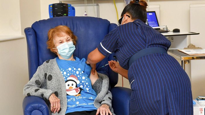 90 year old Margaret Keenan, the first patient in the UK to receive the Pfizer-BioNTech COVID-19 vaccine, administered by nurse May Parsons at University Hospital, Coventry, England, Tuesday Dec. 8, 2020. The United Kingdom, one of the countries hardest hit by the coronavirus, is beginning its vaccination campaign, a key step toward eventually ending the pandemic. (Jacob King/Pool via AP)