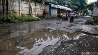 Sejumlah pengendara melintasi jalan rusak dan tergenang di kawasan Jalan Setia Budi, Pondok Kacang Timur, Tangerang Selatan, Selasa (8/12/2020).