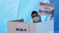 Azizah menuju bilik suara untuk melakukan pencoblosan.