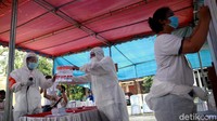 Petugas KPPS menggunakan baju hazmat menghitung kertas suara.