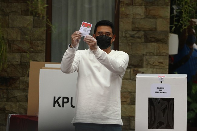 Busana yang lebih kasual menjadi andalan Bobby Nasution saat mencoblos di TPS 22, di Kompleks Tasbih, Medan, Sumatera Utara. Suami putri Presiden Jokowi, Kahiyang Ayu, ini menganakan kaus lengan panjang putih dan jeans. Tidak ketinggalan masker hitam sebagai pelindung. (Foto: ANTARA FOTO/Irsan Mulyadi)