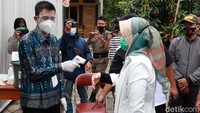 Petugas mengeek suhu tubuh Kurnia Agustina sebelum memasuki TPS.