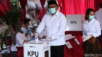 Pradi memasukkan surat suara yang telah dicoblos ke kotak suara. Sementara istrinya hanya menunggu dan tidak ikut memilih karena berprofesi sebagai anggota Polri.