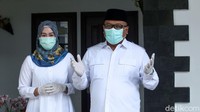 Pradi dan istri yang kompak mengenakan baju warna putih bersiap menuju TPS 15.
