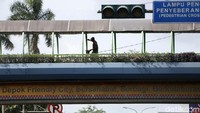 Pekerja melakukan perawatan JPO saat Pilkada sedang berlangsung di Depok.