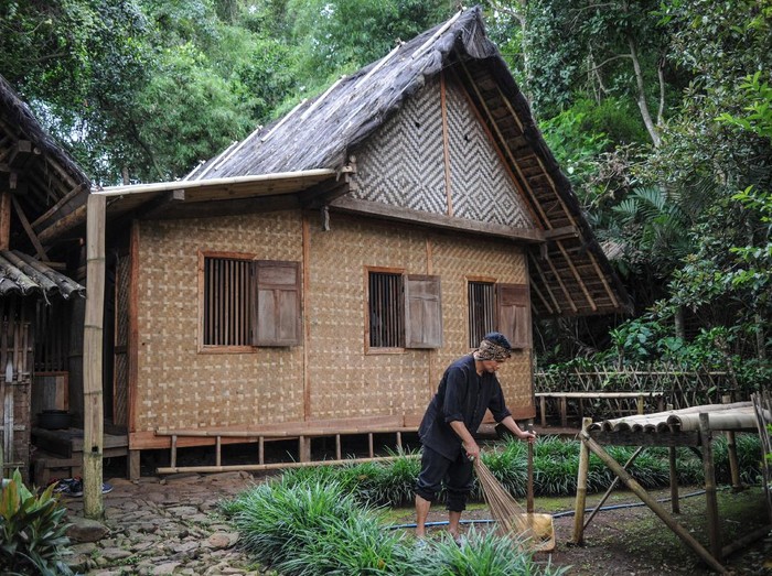 Seorang warga membersihkan halaman rumah di Kampung Adat Cikondang, Lamajang, Pangalengan, Kabupaten Bandung, Jawa Barat, Rabu (9/12/2020). Kampung Adat Cikondang yang telah ada sejak abad ke-19 dan memiliki beberapa peninggalan leluhur kampung tersebut saat ini telah ditetapkan pemerintah sebagai cagar budaya. ANTARA FOTO/Raisan Al Farisi/wsj.