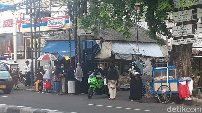 Sejumlah ibu-ibu membagikan bunga dan masker di depan Jl Petamburan III pada Rabu (9/12) sore (Afzal Nur Iman/detikcom)