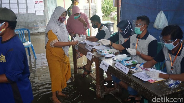 Sejumlah warga di Desa Gebangarum, Kecamatan Bonang, Demak, harus terabas banjir rob untuk pergi ke TPS Pilkada 2020, Rabu (9/12/2020).