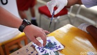 Seorang warga mencelupkan jari ke tinta sebagai tanda telah memberikan hak suaranya.