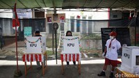 Dengan mengenakan seragam merah putih, seorang petugas terus memantau jalannya pemungutan suara di TPS 49.