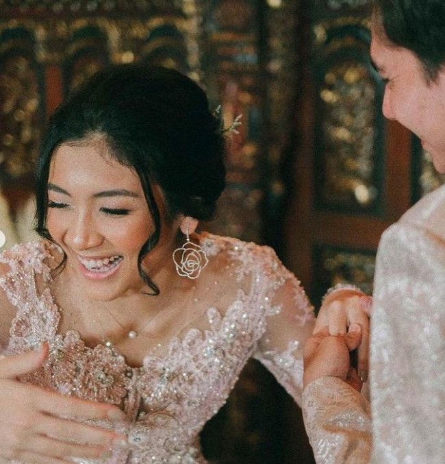 Untuk memberi statement pada penampilan, Canti tampak memakai anting berukuran besar bentuk bunga mawar. Ia juga mengenakan kalung berbandul mutiara sebagai pelengkap penampilan. Foto: Instagram