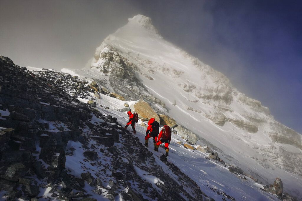 Foto ini dirilis Xinhua News Agency pada bulan Mei 2020: salah satu anggota tim survei China memasang peralatan di Gunung Everest yang oleh warga lokal dinamai Gunung  Qomolangma. China dan Nepal mengumumkan ketinggian baru Gunung Everest pada 8 Desember  2020 (Tashi Tsering/Xinhua via AP, File)