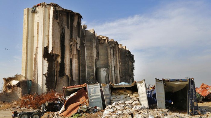 Lebanon Silos A destroyed ship lies near towering grain silos gutted in the massive August explosion at the Beirut port that claimed the lives of more than 200 people, in Beirut, Lebanon, Wednesday, Dec. 2, 2020. A heated debate is underway in Lebanon over the fate of the towering silos with some arguing the gutted silos could collapse at any moment, and must be demolished, while others call for the ruins to be preserved as a grim memorial. (AP Photo/Hussein Malla)