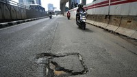 Aspal jalan tampak mengelupas.