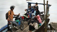 Perahu rakit ini bahkan bisa menampung kendaraan motor warga yang akan menyeberang.  