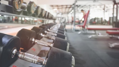 Black dumbbell set. Close up of many metal dumbbells on rack in sport fitness center.