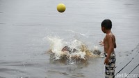 Sejumlah anak tengah asyik bermain dengan teman sebayanya menggunakan peralatan sederhana seperti dengan bola plastik.  