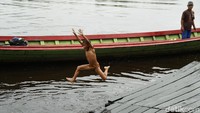 Keceriaan juga terlihat saat mereka melompat dari perahu nelayan yang sedang bersandar di sungai Bantanan.  