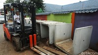 Alat berat dikerahkan untuk mengangkat beton-beton saluran air.