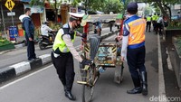Petugas gabungan Polri dan Dishub menertibkan becak yang mengkal sembarangan di Jalan Otista, Bandung, Jumat (11/12/2020).