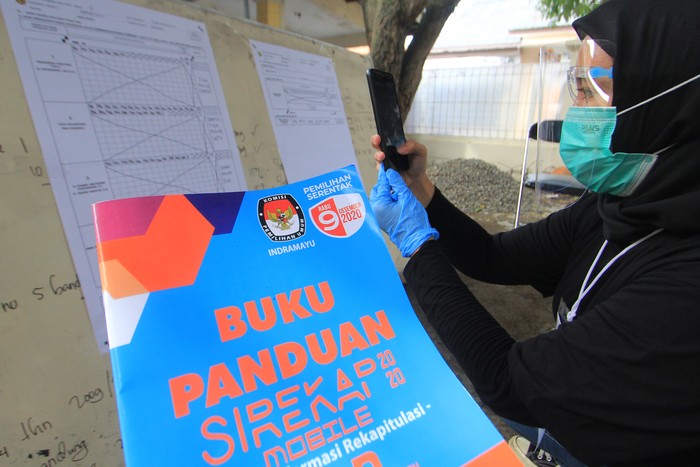 Petugas KPPS mendokumentasikan formulir C1 saat rekapitulasi penghitungan suara dengan menggunakan Sistem Informasi Rekapitulasi (Sirekap) di TPS 04 Karanganyar, Indramayu, Jawa Barat, Rabu (9/10/2020). Penggunaan aplikasi Sirekap itu sebagai sarana publikasi hasil penghitungan suara dan rekapitulasi hasil penghitungan suara dalam pelaksanaan pilkada 2020. ANTARA FOTO/Dedhez Anggara/aww.