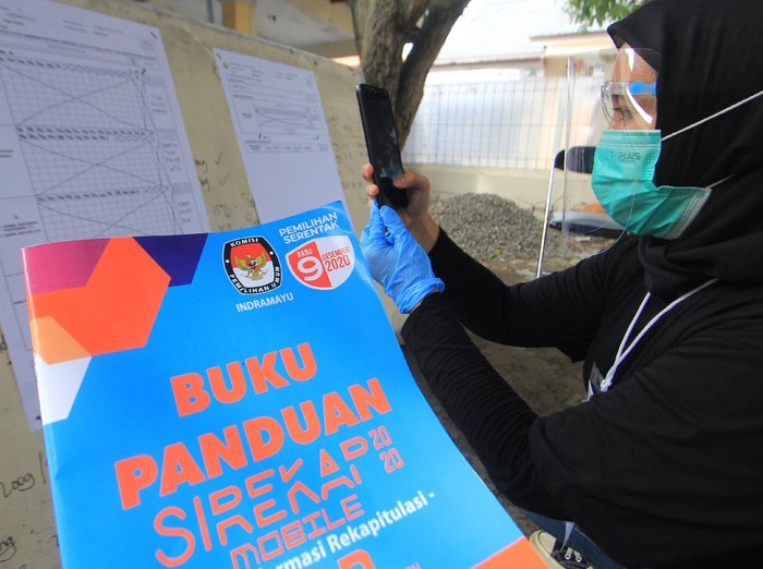 Petugas KPPS mendokumentasikan formulir C1 saat rekapitulasi penghitungan suara dengan menggunakan Sistem Informasi Rekapitulasi (Sirekap) di TPS 04 Karanganyar, Indramayu, Jawa Barat, Rabu (9/10/2020). Penggunaan aplikasi Sirekap itu sebagai sarana publikasi hasil penghitungan suara dan rekapitulasi hasil penghitungan suara dalam pelaksanaan pilkada 2020. ANTARA FOTO/Dedhez Anggara/aww.