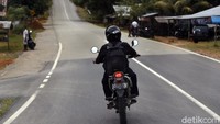 Mantri BRI, Jefrizal mengendarai motornya melintasi perbukitan di perbatasan Aruk untuk menemui nasabah.  