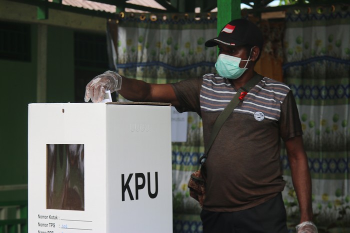 Warga Kabupaten Asmat melakukan pencoblosan dengan menerapkan protokol Kesehatan di TPS 006 Distrik Agats, Kabupaten Asmat, Papua, Rabu (9/12/2020). Pilkada Asmat 2020 diikuti dua pasangan calon, yakni pasangan petahana Elisa Kambu  Thomas E. Safanpo yang diusung partai politik dan Yulianus P. Aituru  Bonifasius Jakfu dari jalur perseorangan. ANTARA FOTO/Sevianto Pakiding/wpa/wsj.