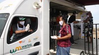 Petugas Warteg Mobile Laznas BSM Umat membagikan makanan siap saji untuk masyarakat kurang mampu ditengah pemukiman daerah Cilincing, Jakarta Utara, Jumat (11/12/20). 