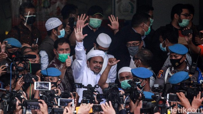 Habib Rizieq Shihab tiba di Polda Metro Jaya sebagai tersangka kasus kerumunan di Petamburan. Setiba di Polda Metro Jaya, ia sempat mengacungkan jempol.