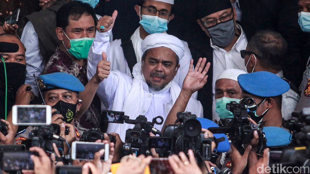 Habib Rizieq Shihab tiba di Polda Metro Jaya sebagai tersangka kasus kerumunan di Petamburan. Setiba di Polda Metro Jaya, ia sempat mengacungkan jempol.