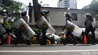 Mereka berbaris dilengkapi dengan tameng dan pelindung kepala.