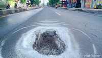 Lubang jalan itu sudah ada sejak beberapa pekan terakhir. Intensitas hujan yang tinggi membuat jalan semain rusak.