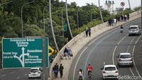 Baik pesepeda maupun pejalan kaki beramai-ramai menaiki jalan layang ini.