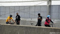 Pesepeda beristirahat di sisi jembatan.