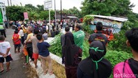 Warga berkumpul menonton bangkai mobil yang tertabrak kereta.