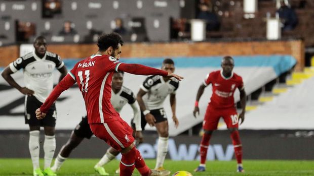 Fulham vs Liverpool LONDON, ENGLAND - DECEMBER 13: Mohamed Salah of Liverpool scores their team's first goal from the penalty spot during the Premier League match between Fulham and Liverpool at Craven Cottage on December 13, 2020 in London, England. A limited number of spectators (2000) are welcomed back to stadiums to watch elite football across England. This was following easing of restrictions on spectators in tiers one and two areas only. (Photo by Matt Dunham - Pool/Getty Images)
