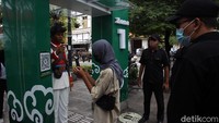 Petugas Jogoboro berjaga dan memberikan arahan kepada wisatawan di depan Gerbang detektor suhu tubuh yang terpasang di jalur pedestrian Malioboro, Yogyakarta, Senin (14/12/2020).