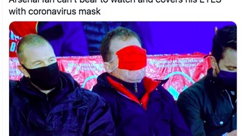 Foto ini viral menampakkan fans Arsenal tak mau lagi nonton dan menutupi wajahnya dengan masker. Foto: Twitter
