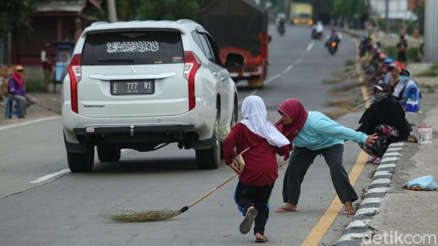 Kehadiran gerombolan orang membawa sapu jadi pemandangan umum saat melintasi Jembatan Sewo, Indramayu. Di sana mereka kumpulkan koin yang dilempar pengendara.