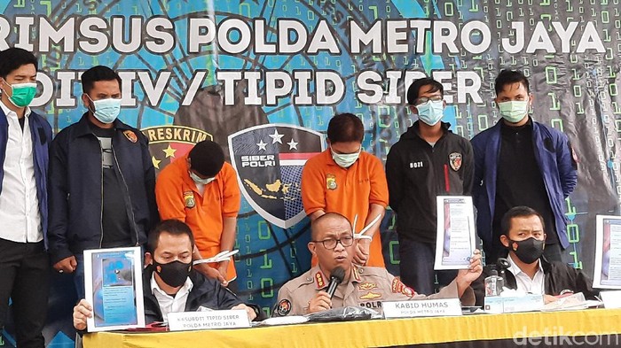 S (40), pelaku penyebar ancaman bunuh Kapolda Metro berompi oranye sebelah kiri (Yogi Ernes/detikcom).