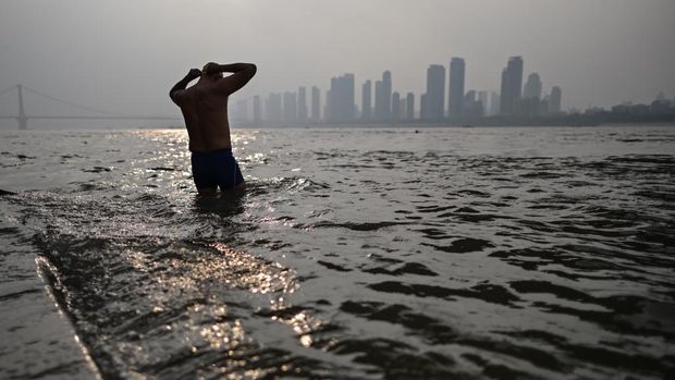 sekelompok orang bersiap-siap berenang di Sunyai WUhan pada 20 November 20 2020 (Photo by Hector RETAMAL / AFP)