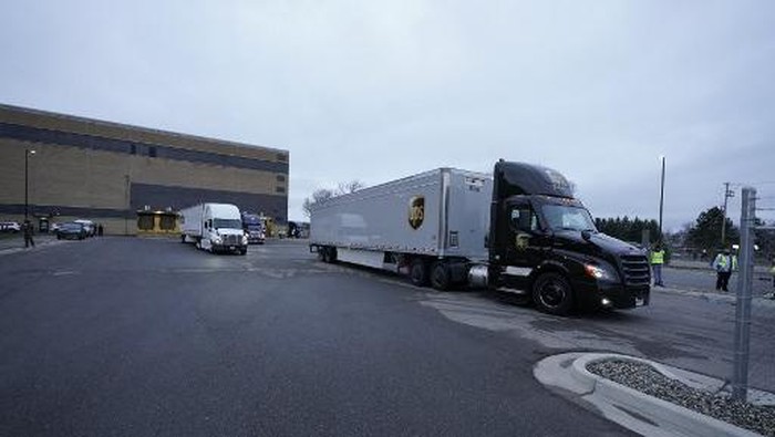 LANSING, MI - DECEMBER 13: A UPS worker hooks a UPS truck to a trailer containing shipments of the Pfizer And BioNTech COVID-19 vaccine at the Capital Region International Airport on December 13, 2020 in Lansing, Michigan. The first doses of the coronavirus (COVID-19) vaccine will be distributed to all 50 states.   Rey Del Rio/Getty Images/AFP