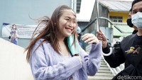 Angin kencang yang menyibak rambut panjangnya itu pun tak membuat Ayu kehilangan senyumannya. Pool/Palevi S/detikFoto.