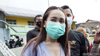 Ayu tampak berpose di depan awak media sambil ditemani asistennya. Pool/Palevi S/detikFoto.