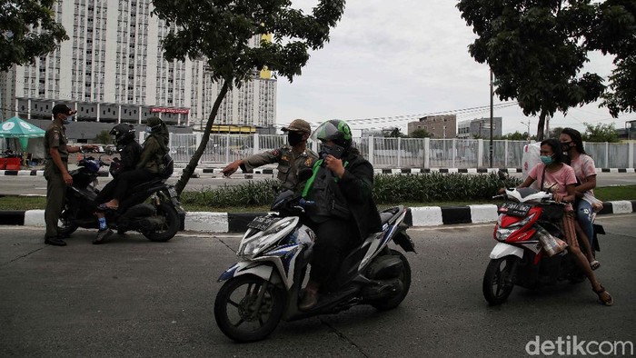 Kasus Harian COVID-19 di Jakarta Masih Tertinggi Petugas Satpol PP melakukan operasi tertib masker di kawasan depan Rumah Sakit Darurat COVID-19 Wisma Atlet Kemayoran, Jakarta Pusat, Selasa (15/19).
